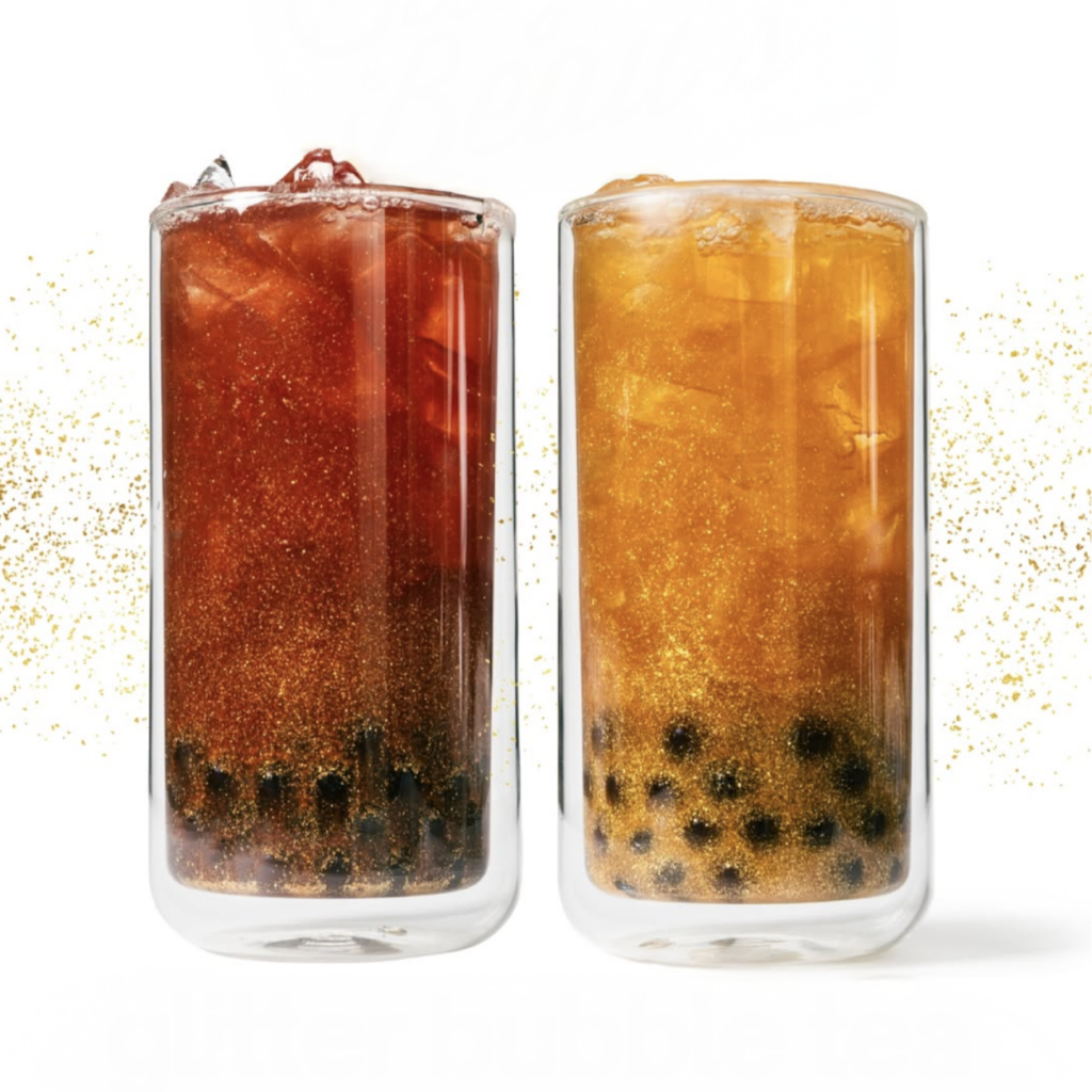 Two tall glasses filled with iced bubble tea, one dark and one light. Both have black tapioca pearls and shimmering golden glitter, creating a festive and refreshing vibe.
